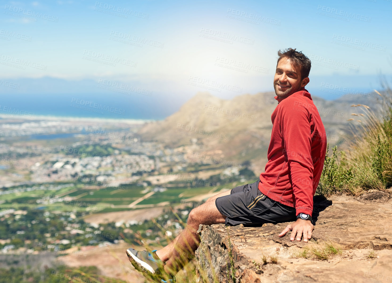 Buy stock photo Portrait of a sporty young man admiring the view from the top of a mountain