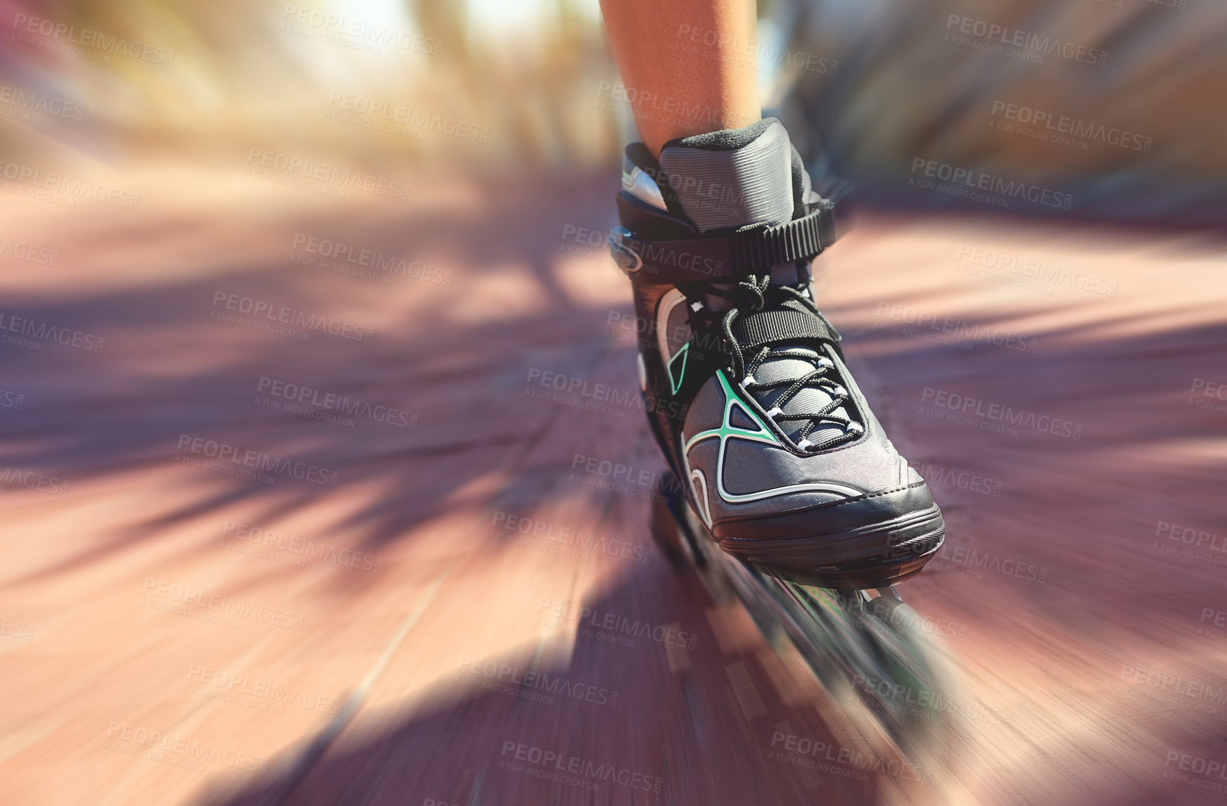 Buy stock photo Closeup shot of a young woman's feet in rollerblades speeding down a park path