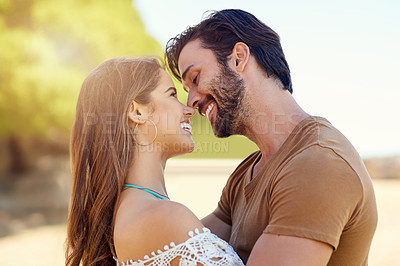 Buy stock photo Shot of a smiling young couple embracing while enjoying a day together at the park