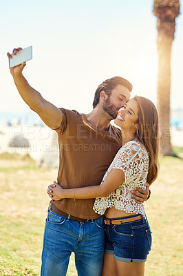 Buy stock photo Shot of a smiling young couple taking a selfie together while  enjoying a day in the park