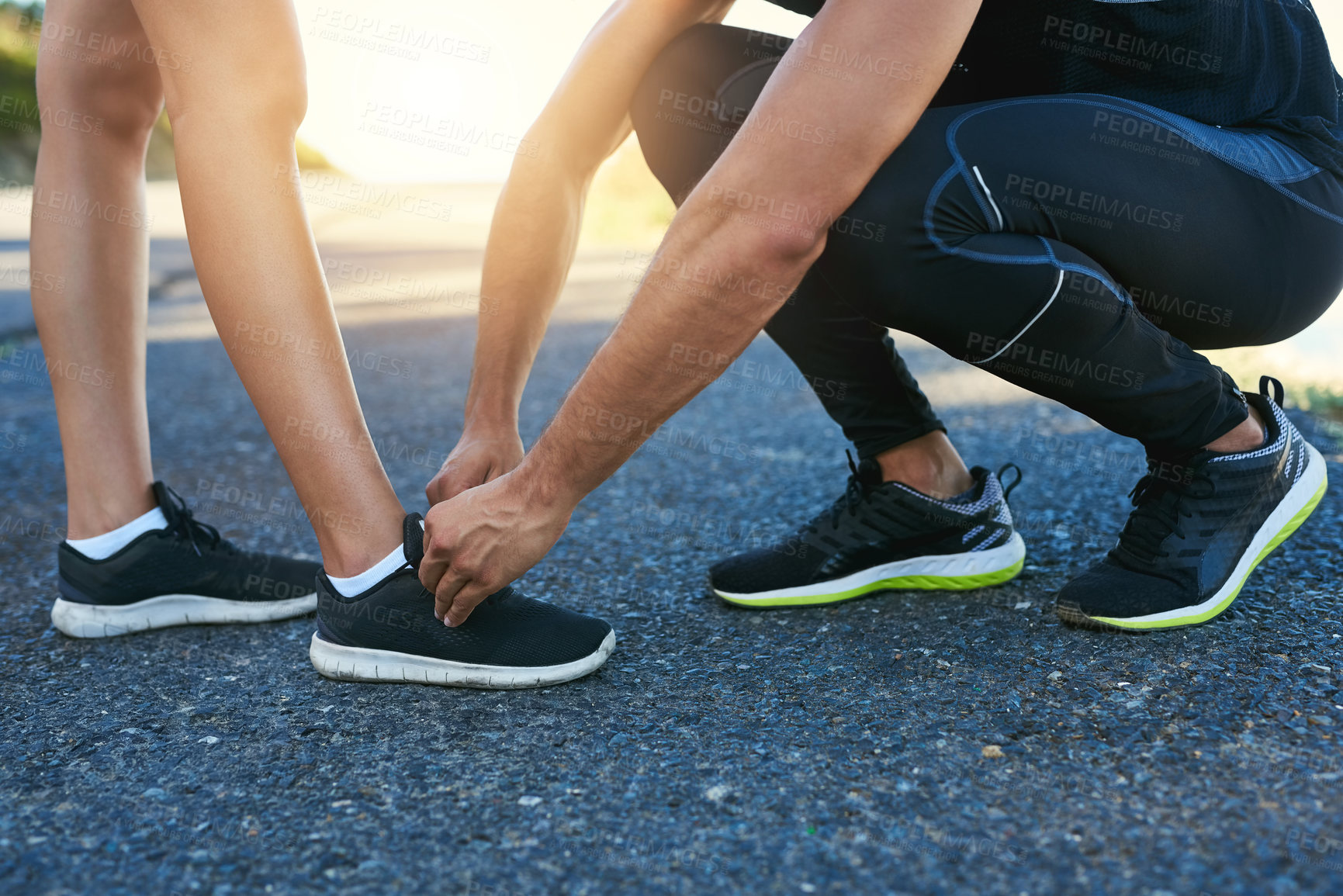 Buy stock photo Cropped shot of a man typing his girlfriend's laces while out for a run
