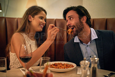 Buy stock photo Love, restaurant date and woman feeding man spaghetti on valentines day, happy and romantic dinner. Romance, valentine and food with wine, couple celebrate marriage or relationship with time together
