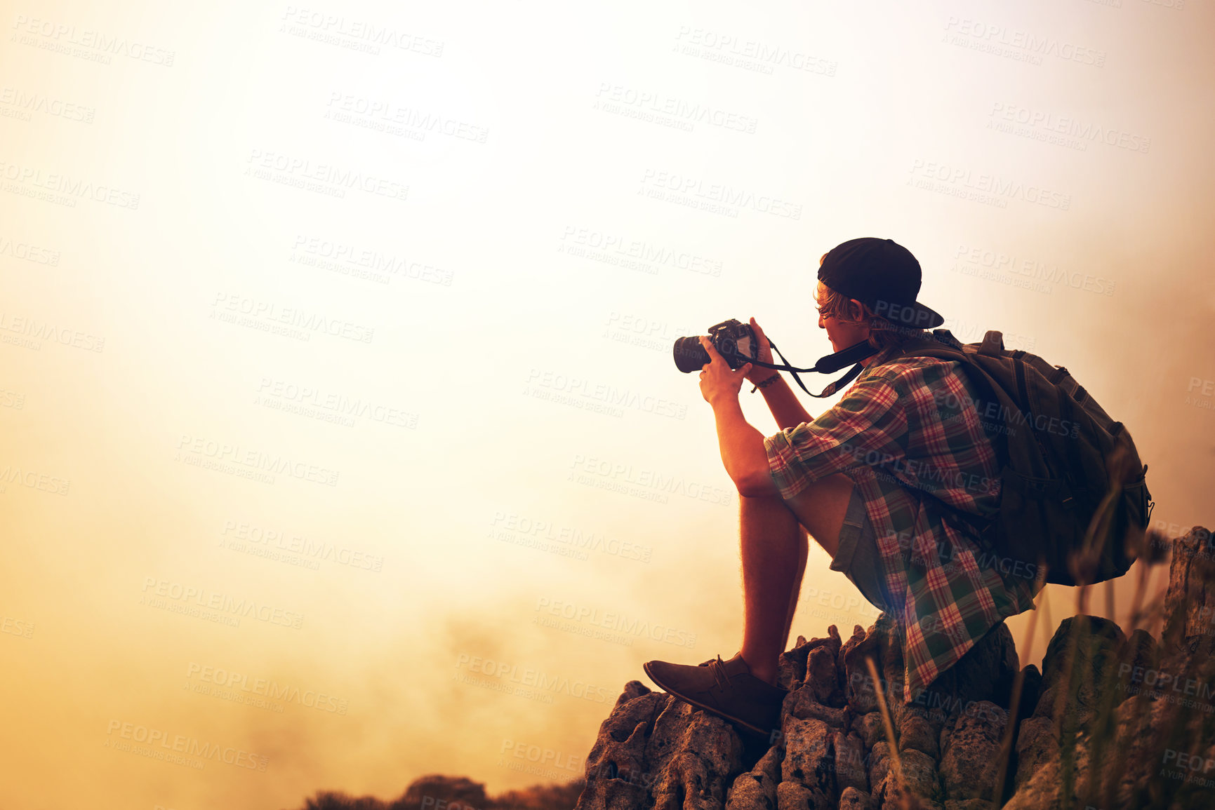 Buy stock photo Shot of a young photographer taking a picture of a foggy landscape from the top of a mountain