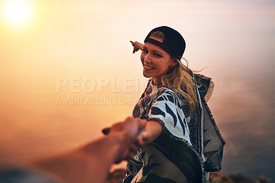 Buy stock photo Portrait of a happy young hiker pointing out a foggy view while holing her boyfriend's hand