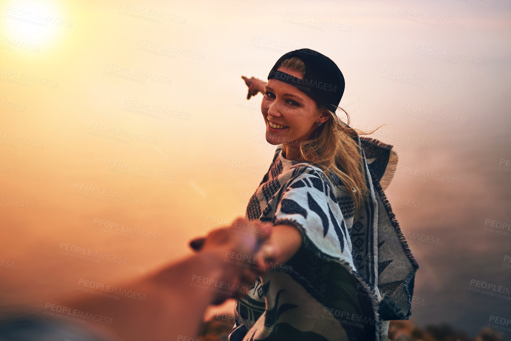 Buy stock photo Portrait of a happy young hiker pointing out a foggy view while holing her boyfriend's hand