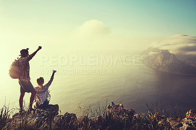 Buy stock photo Rearview shot of an unidentifiable young couple admiring the view from a mountain peak together