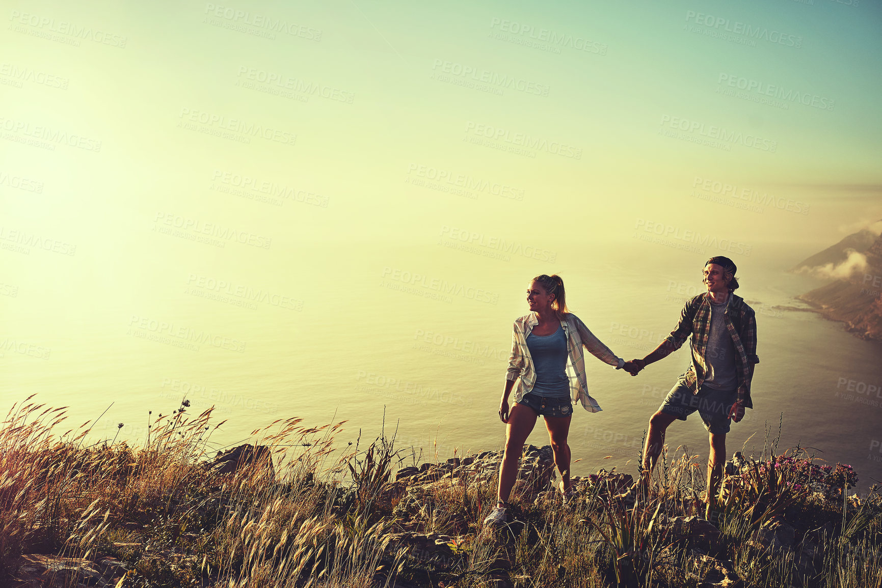 Buy stock photo Shot of an affectionate young couple bonding while out on a hike together