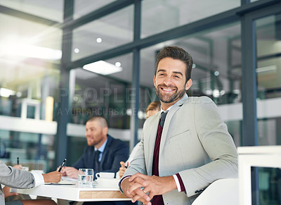 Buy stock photo Portrait of a businessman sitting in an office with his colleagues in the background
