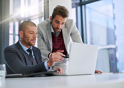 Buy stock photo Cropped shot of two businessmen working together on a laptop in an office
