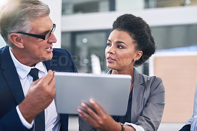 Buy stock photo Cropped shot of two businesspeople working together on a digital tablet in an office