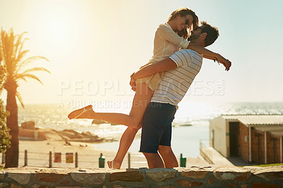 Buy stock photo Smile, couple and lifting with love outdoor for anniversary celebration, support and hug of romance commitment. Excited, man and woman with embrace of engagement proposal, date and beach sunset