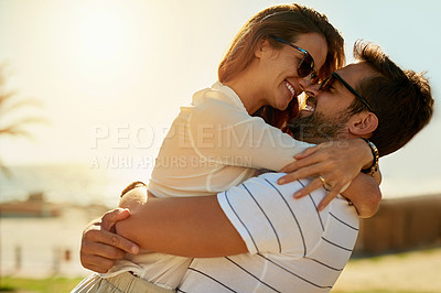 Buy stock photo Shot of a happy young couple embracing on a summer’s day outdoors