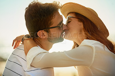 Buy stock photo Shot of a young couple kissing on a summer’s day outdoors