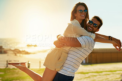 Buy stock photo Shot of a happy young couple embracing on a summer’s day outdoors