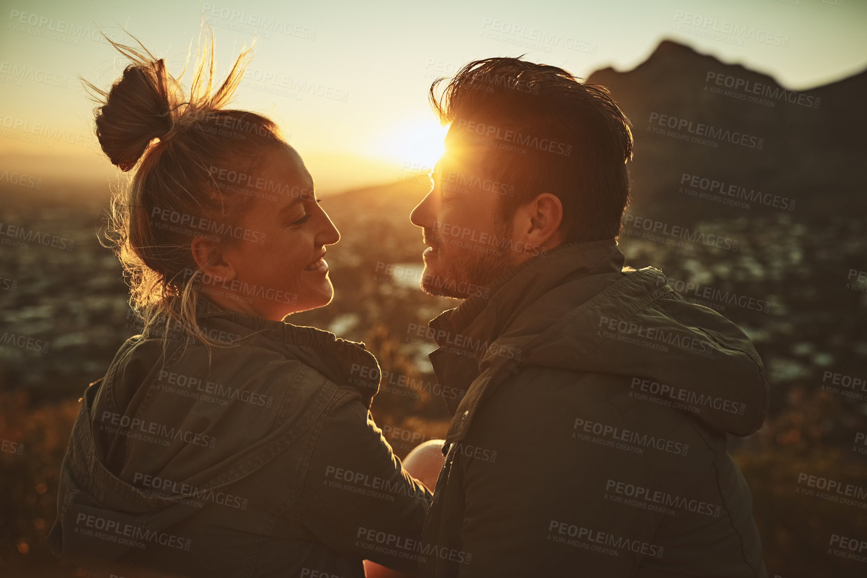 Buy stock photo Couple, sunset and mountain for travel in outdoor, talking and together on vacation. People, nature and support for freedom on holiday, conversation and romance on cliff for love in relationship