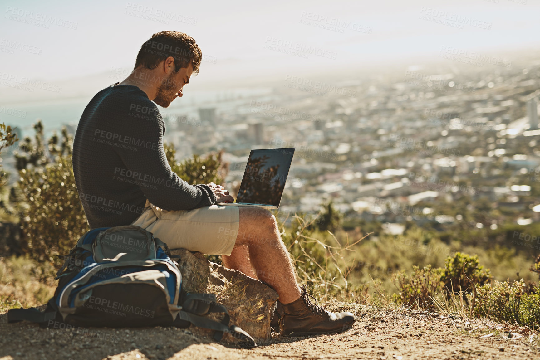 Buy stock photo Exploration, man and hiker with laptop outdoor for remote work, connection and location review. Male person, freedom and computer in nature for typing, research and planning adventure blog or website