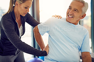 Buy stock photo Shot of a physiotherapist examining a senior patient with back pain in her office