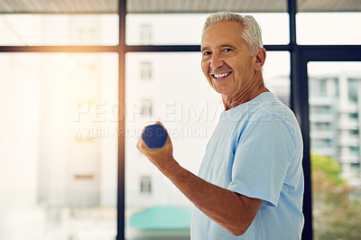 Buy stock photo Portrait of a fit senior smiling while lifting weights at the fitness center