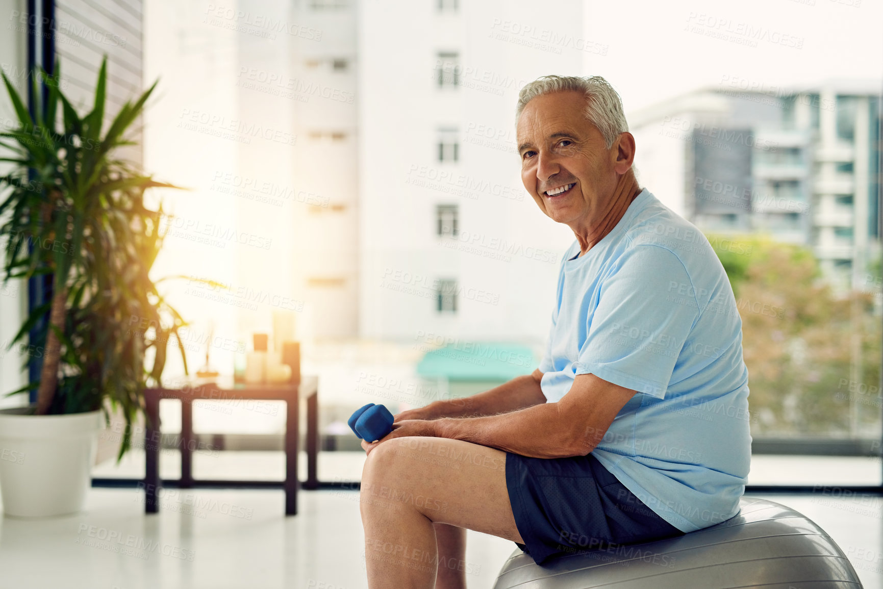 Buy stock photo Portrait of a fit senior smiling while lifting weights at the fitness center