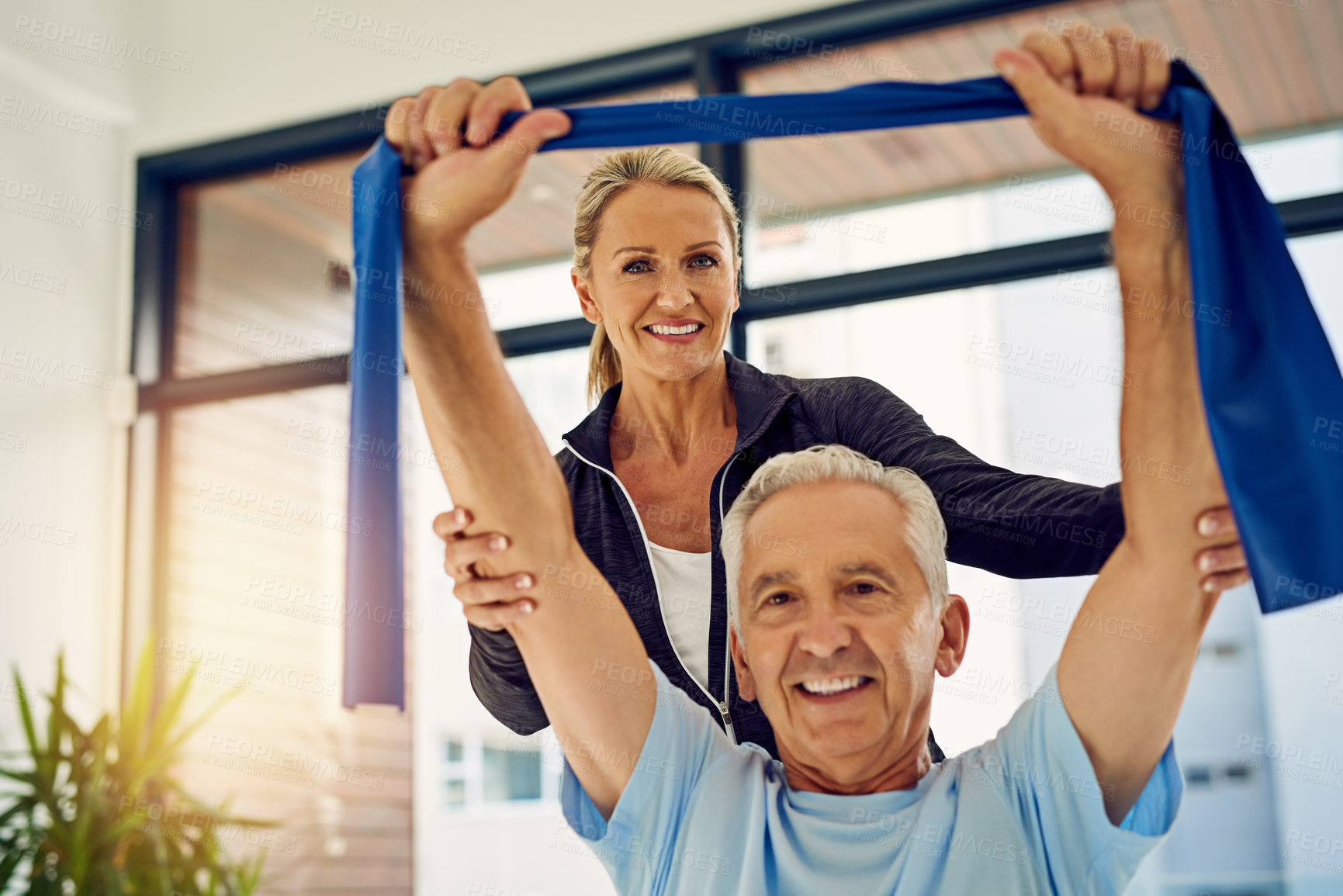 Buy stock photo Mature, man and portrait with resistance band or woman physiotherapist for physical therapy, mobility exercise and arthritis management. Geriatric physiotherapy, stretching arm and rehabilitation.