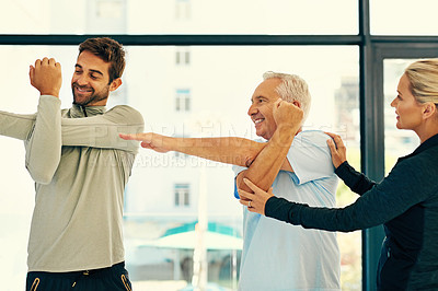 Buy stock photo Shot of two physiotherapists helping their senior patient with his exercises