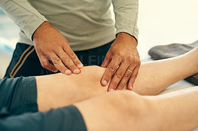Buy stock photo Cropped shot of an unidentifiable physiotherapist massaging his patient's knee