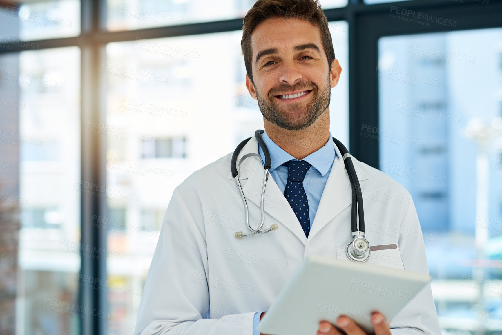 Buy stock photo Portrait of a busy doctor checking a patient's medical records on his tablet