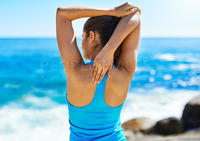 Buy stock photo Shot of a young woman stretching before her run