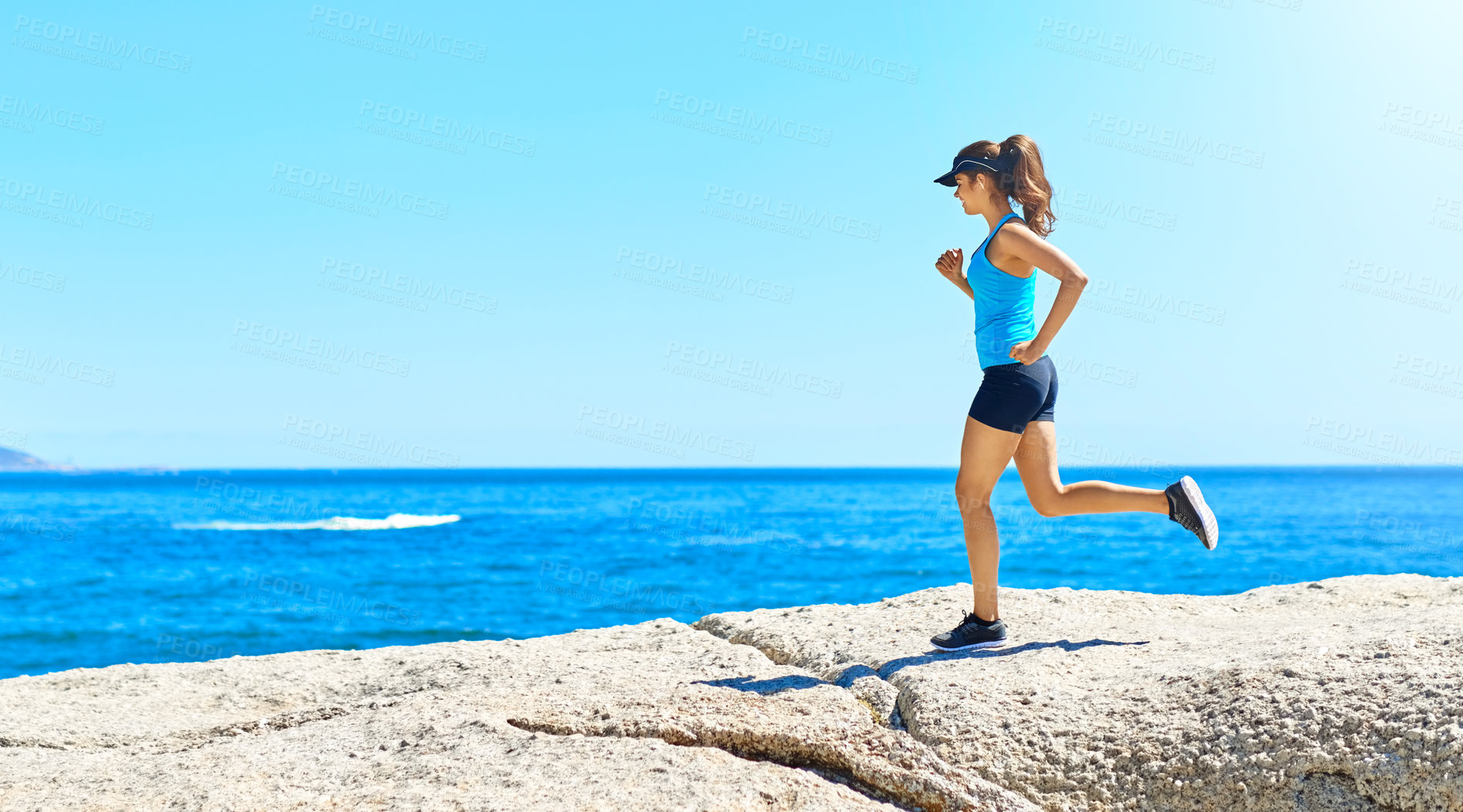 Buy stock photo Fitness, running and woman on beach with blue sky, marathon training and outdoor exercise on mockup space. Ocean, rocks and girl runner on morning workout in nature for body care, health and wellness