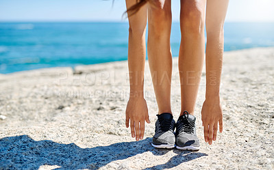 Buy stock photo Woman, legs and stretching with hands on beach for fitness, exercise or warm up on rock in nature. Female person, feet or reaching for toes, workout or yoga in pilates or balance by ocean coast