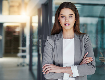 Buy stock photo Portrait of an attractive young businesswoman standing with her arms crossed in the office