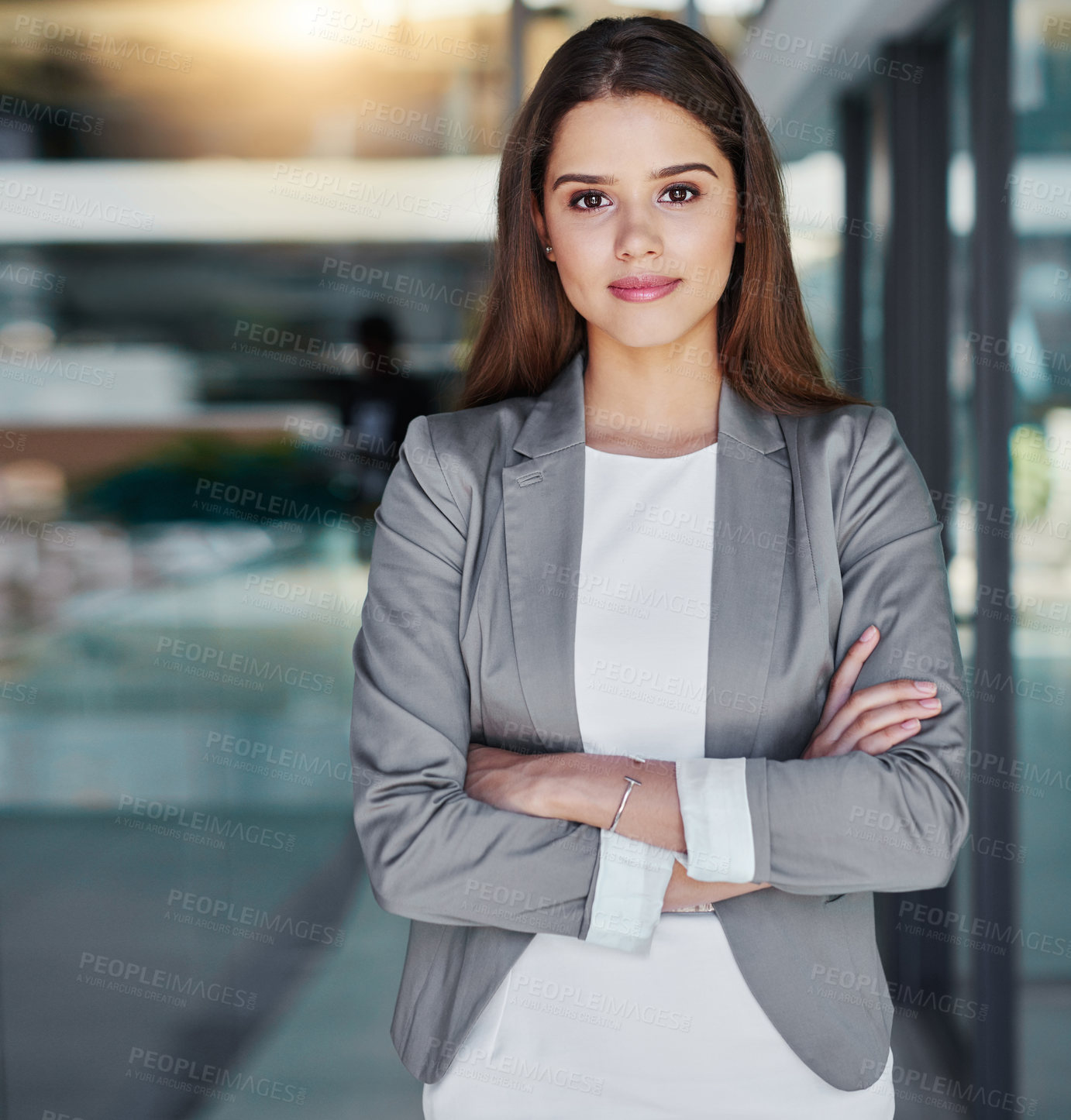 Buy stock photo Portrait of an attractive young businesswoman standing with her arms crossed in the office
