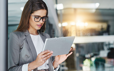 Buy stock photo Cropped shot of an attractive young businesswoman using her tablet in the office