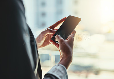 Buy stock photo Shot of an unrecognizable young businesswoman using her cellphone in the office
