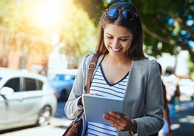 Buy stock photo Cropped shot of an attractive young woman using her tablet while commuting to work