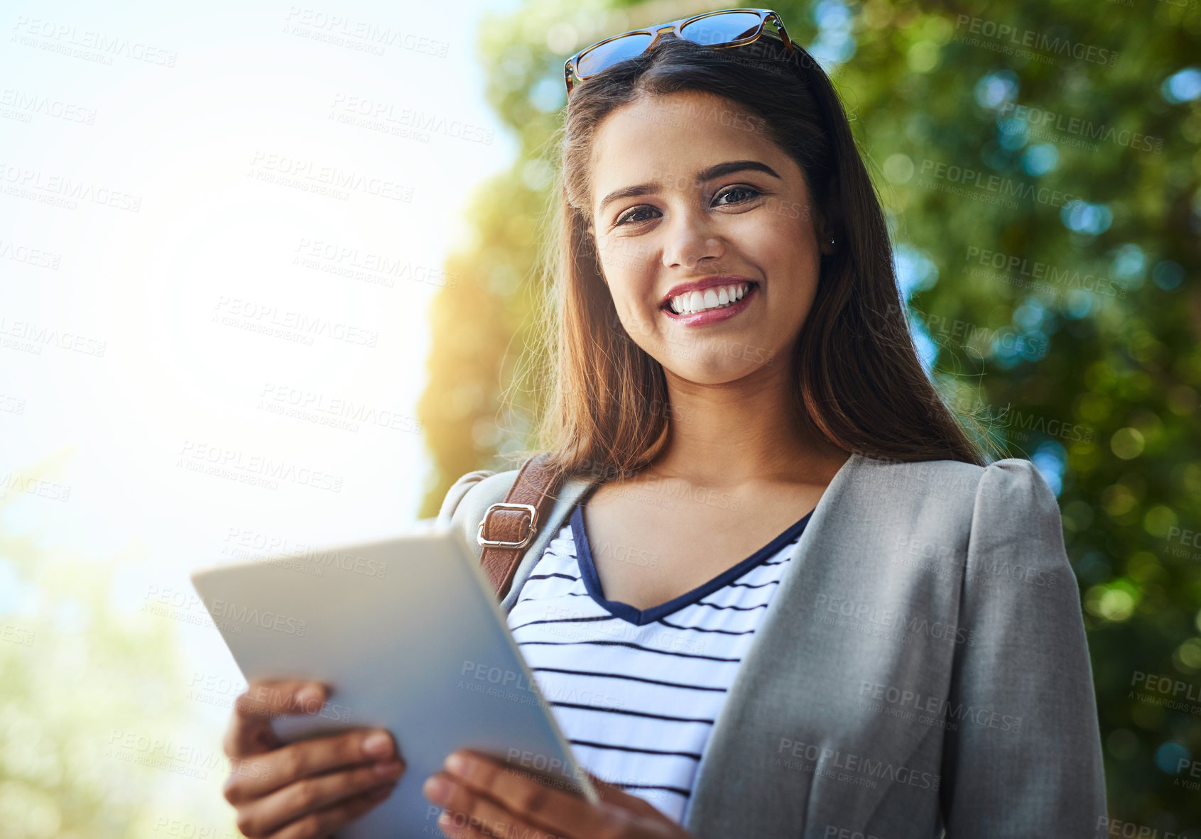 Buy stock photo Cropped portrait of an attractive young woman using her tablet while commuting to work