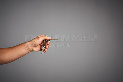 Buy stock photo Studio shot of an unidentifiable hand holding out a car key against a gray background