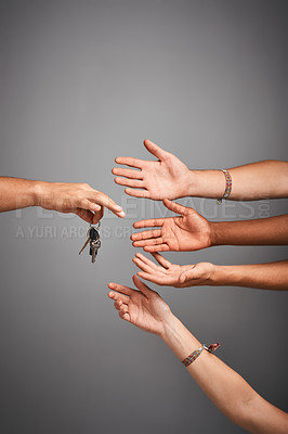 Buy stock photo Studio shot of unidentifiable hands reaching for a set of keys against a gray background