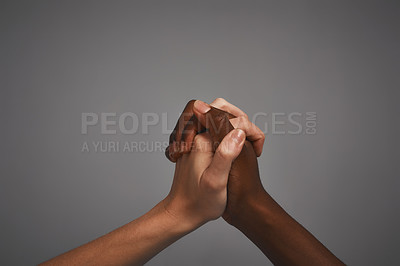 Buy stock photo Studio shot of unidentifiable hands holding on to each other against a gray background