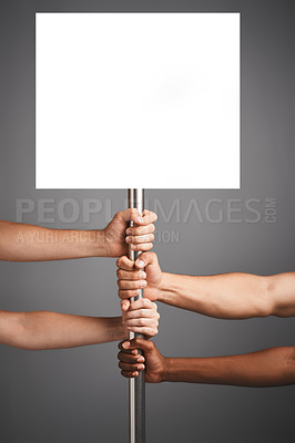 Buy stock photo Studio shot of unidentifiable hands holding on to a poster against a gray background