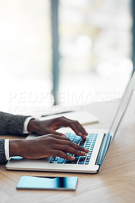 Buy stock photo Shot of an unidentifiable young businessman working on his laptop at a table in the office