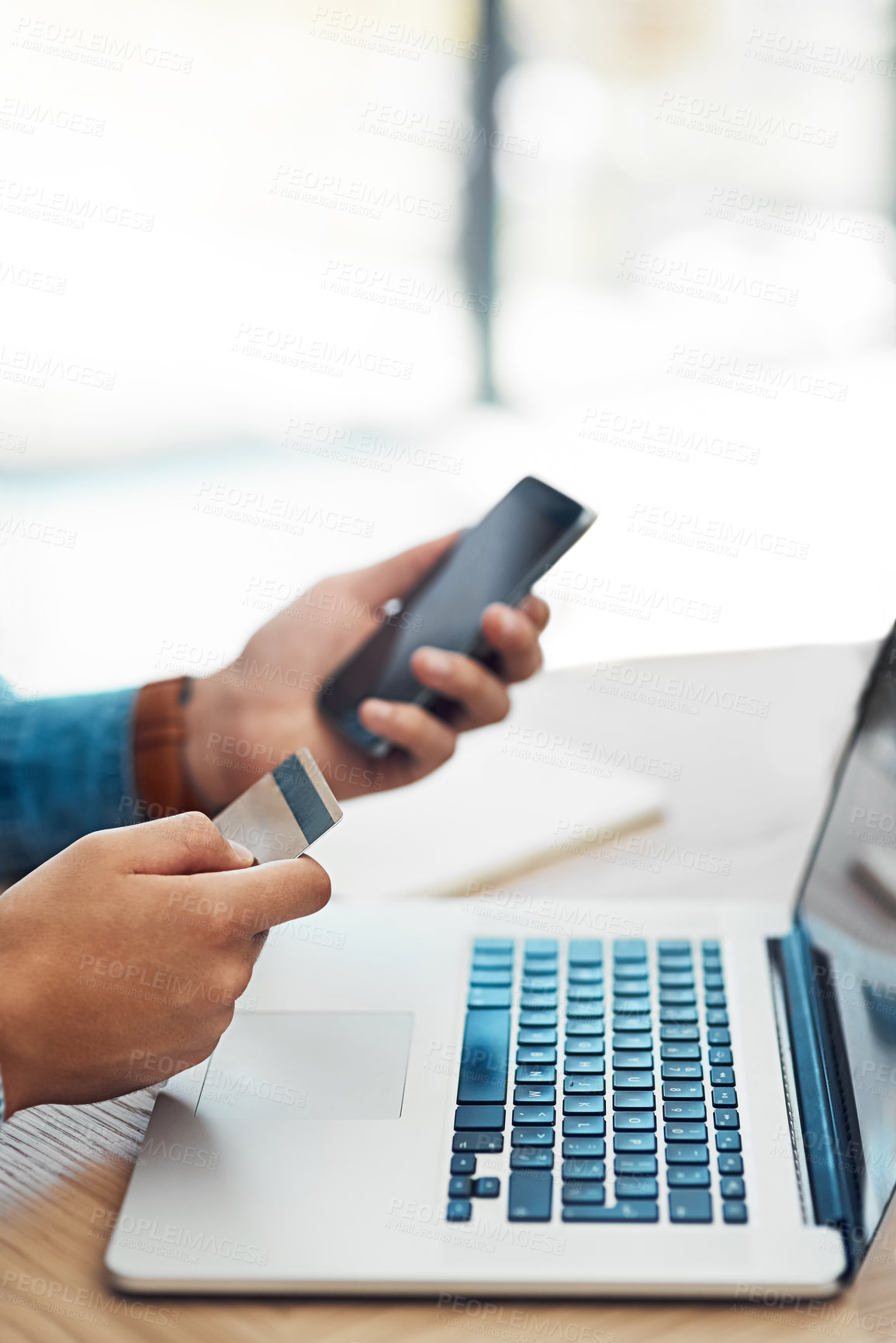 Buy stock photo Shot of an unidentifiable young businessman using wireless technology to make an online purchase in the office