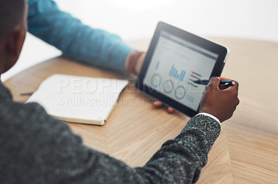 Buy stock photo Shot of two unidentifiable businessmen looking at graphs together on a tablet in the office