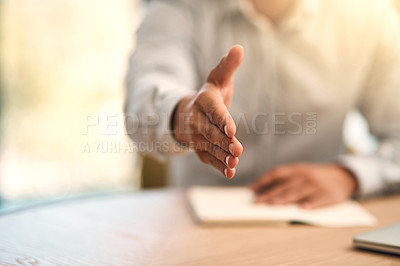 Buy stock photo Shot of an unidentifiable businessman extending his hand for a handshake across a table in the office