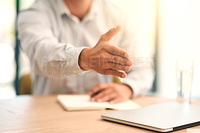 Buy stock photo Shot of an unidentifiable businessman extending his hand for a handshake across a table in the office