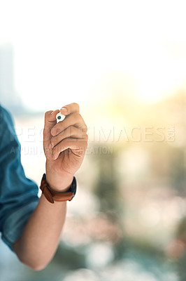 Buy stock photo Shot of an unidentifiable young entrepreneur using a marker to write on a glass screen in the office
