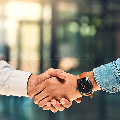 Buy stock photo Shot of two unidentifiable young  business partners shaking hands in the office