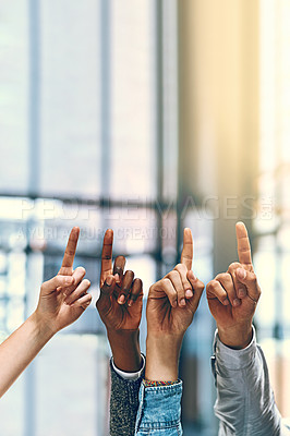 Buy stock photo Cropped shot of a group of unrecognizable businesspeople pointing upwards