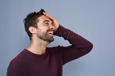 Buy stock photo Studio shot of a handsome young man looking relieved against a gray background