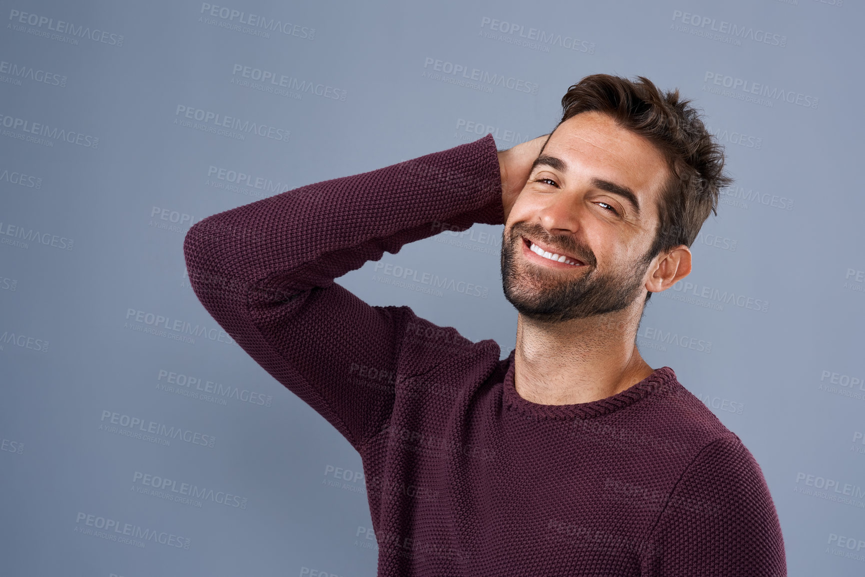 Buy stock photo Studio shot of a handsome and happy young man posing against a gray background